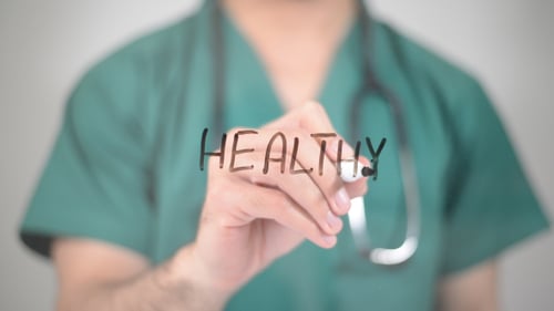 Doctor Writing the Word Healthy in Close Up