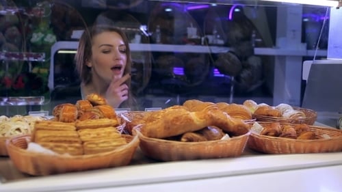 Girl Choosing Cakes From The Counter In Cafe