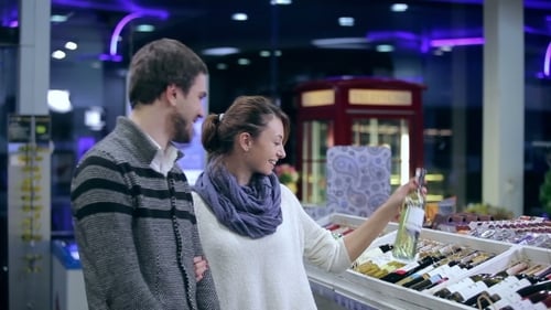 Young Couple Choosing Wine In Shop
