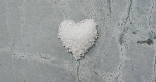 Video of pile of salt in shape of heart on stone kitchen worktop