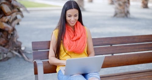 Woman Using Laptop on Park Bench
