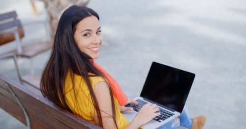 Woman Uses Laptop While Sitting on Park Bench