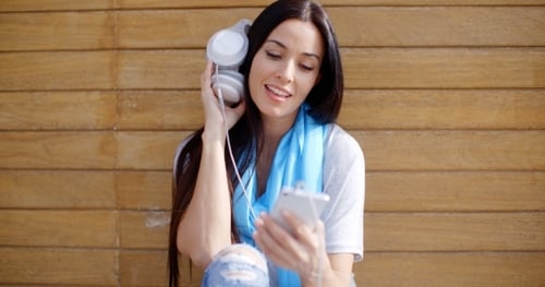 Woman Listening to Headphones in an Urban Setting