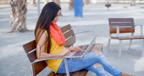 Woman with Laptop Relaxing on Park Bench