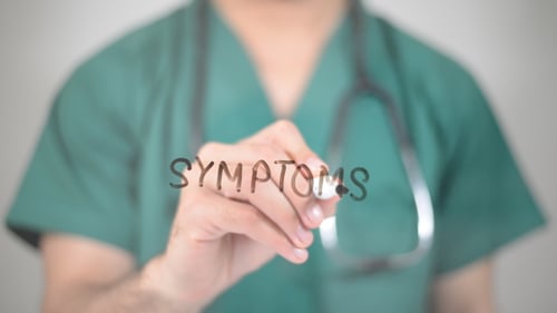 Doctor Writing Symptoms on a Clear Surface