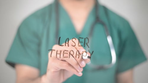 Doctor Writes 'Laser Therapy' on Clear Surface