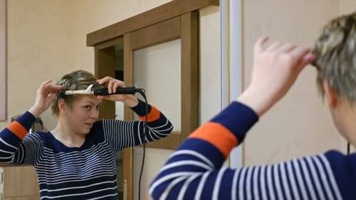 Woman Styles Short Hair with Curling Iron