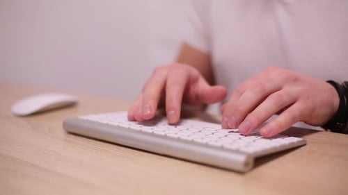 Hands Typing on Silver Computer Keyboard Close Up