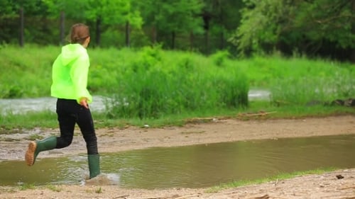 Happy Girl Playing In Puddle Near River