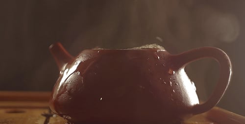 Water Being Poured into Brown Teapot