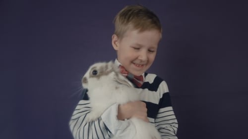Smiling Boy Holding a Cute White Bunny