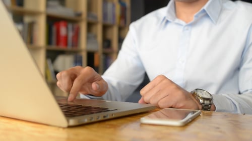 Man Typing on Laptop in Office Setting