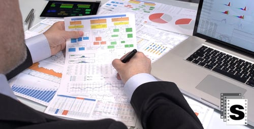 Man Reviews Financial Documents at Workplace