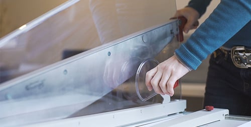 Hands Cutting Paper with Paper Cutter