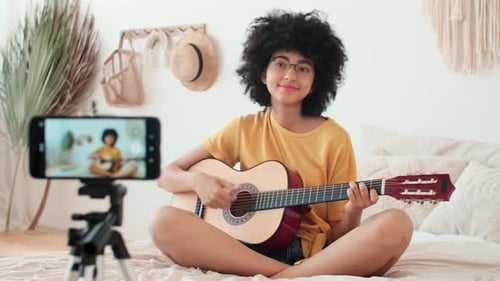 Young Woman Playing Guitar for Phone Video