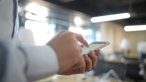 Hand Types on Smartphone in Bright Office