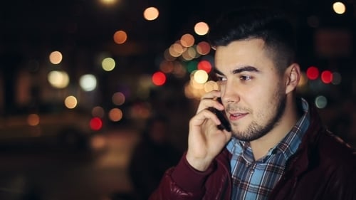 Young Man Calling On Mobile Phone At Night In City.
