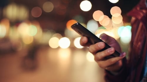 Hand Using Cell Phone At Night in City