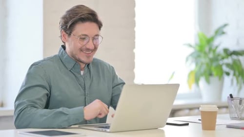 Man Talking on Laptop Video Conference at Desk