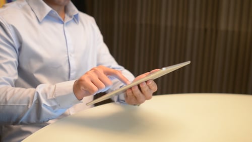 Man Using Tablet Device at Table Indoors