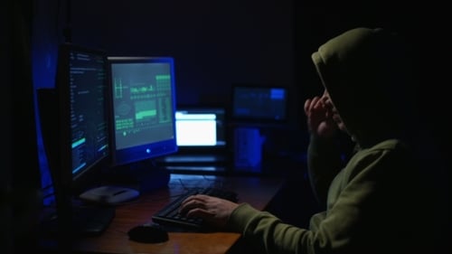 Person Coding at Multiple Computer Screens at Night