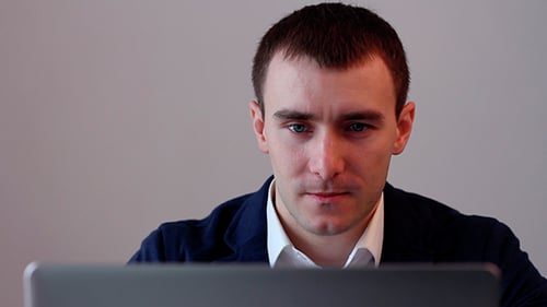 Man Working at Laptop in an Office Close Up