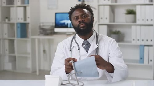Friendly Doctor Explains Blood Pressure Monitoring At Desk