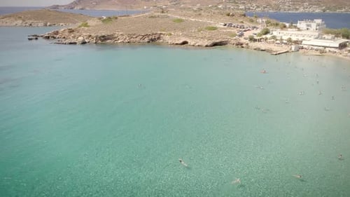 Aerial view of people swimming on beach Alithini, Syros island in Greece.