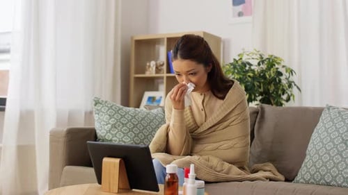 Sick Woman Wrapped in Blanket on Sofa