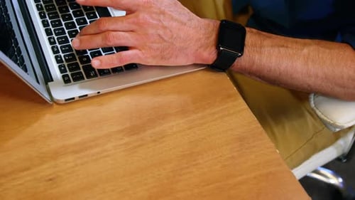 Adult Typing on Laptop in Workplace