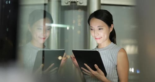 Woman Smiling Using Tablet at Night in the City