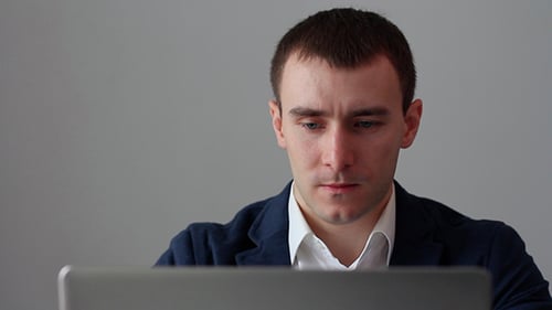 Man Works On Laptop in Office