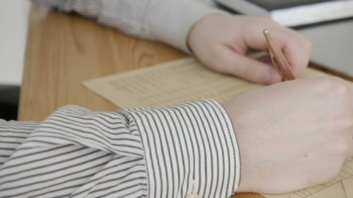 Businessman Sitting At Office Desk Signing a Contract