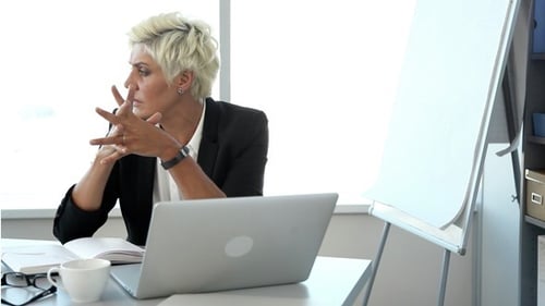 Professional Woman Thinking at Her Office Desk