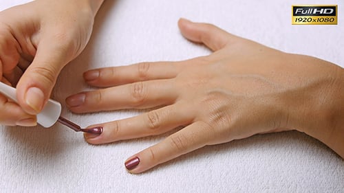 Applying Dark Red Nail Polish Manicure Close Up