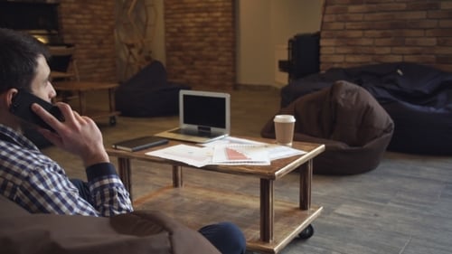 Young Adult Talking on Phone in Office Setting