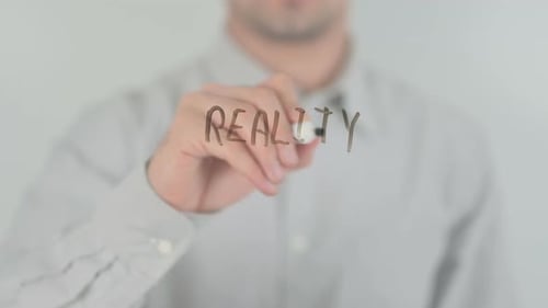 Man Writes the Word Reality on Glass