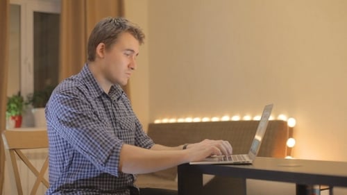 Young Adult Working at Laptop in Home Office