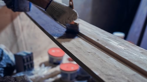 Verfahren zum Bemalen der Kiefernholzbretter mit dem Pinsel und der lila Farbe