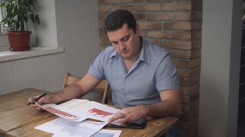 Der
Manager analysiert die Verkaufscharts, während er im Büro sitzt.