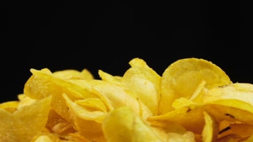 Close Up of Golden Potato Chips on Black