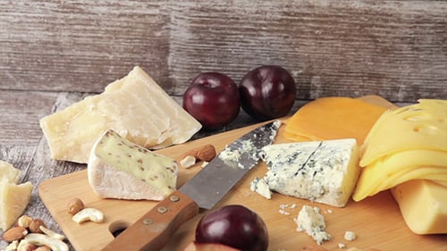 Delicious Cheeses and Fruit on Cutting Board
