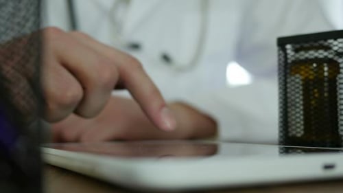 Doctor Using Tablet in Office Close Up