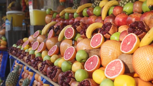 Colorful Fruit Display with Pomegranates, Grapefruits, and Bananas