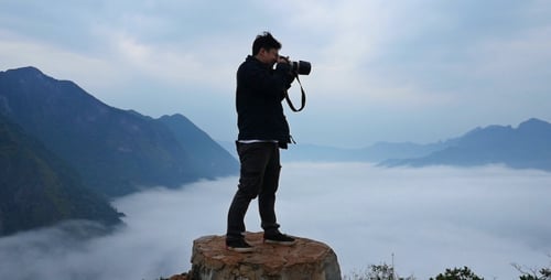 Photographer Shooting on Top of Mountain