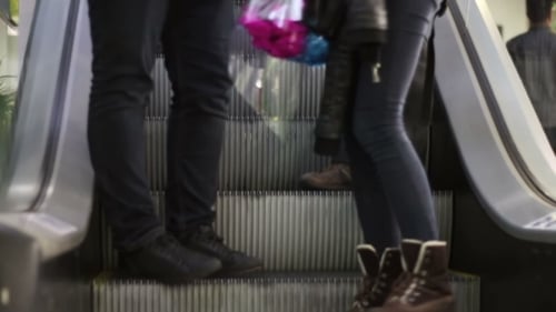 Anonyme Menschen gehen auf dem Rolltreppenlift im Einkaufszentrum