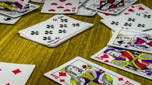 Scattered Playing Cards on Wood Table