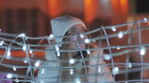 The Girl Touches the New Year's Lights of the Night City