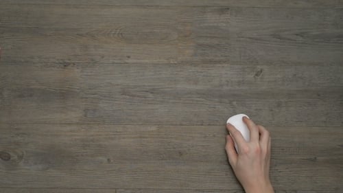 Hand Using Computer Mouse on Wood-Look Surface