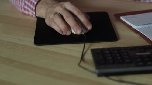Man Working With a Computer Mouse At The Table